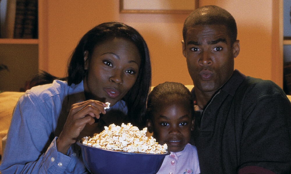 Family watching scary movie at home