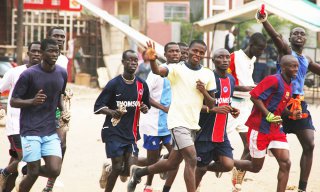 A group of small African boys running through the streets