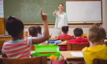 Teacher calling on pupil with raised hand during class