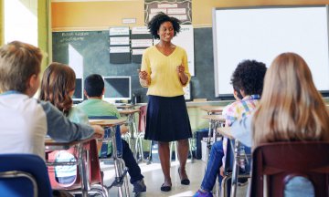 Female African American teacher standing, talking to class
