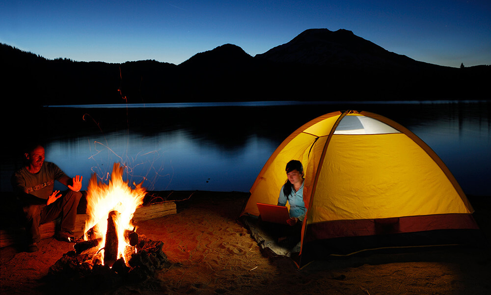 Camping couple by fire on Sparks Lake shore