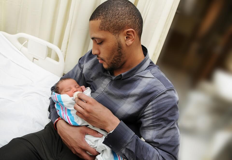 African American Father Holding and Feeding Newborn Infant Baby