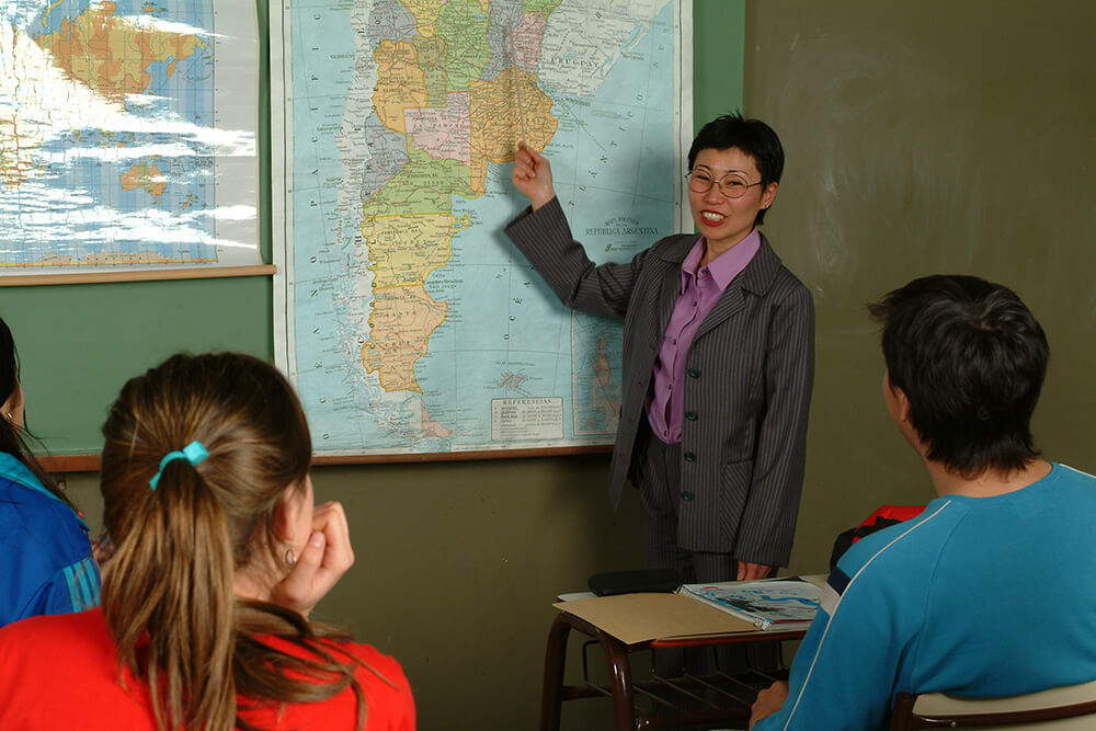 Geography teacher pointing at a map