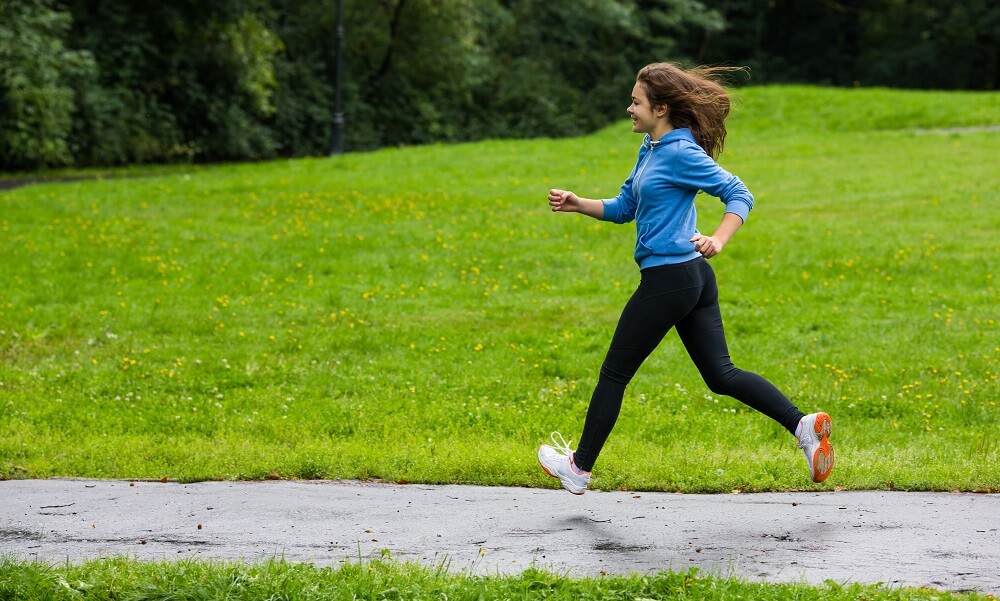Girl running, jumping in park