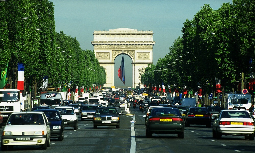 Cars on Champs Élysées, in front of Arc de Triomphe, in Paris, France