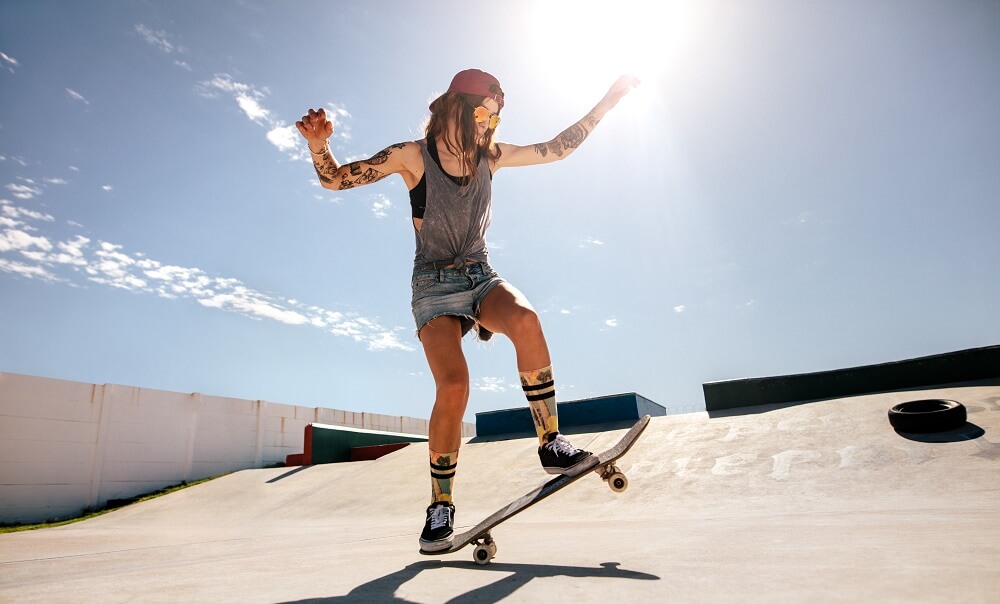 Female skater skateboarding at skate park.