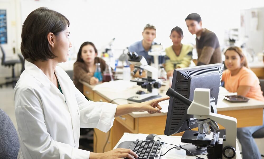 Side profile of a lab technician in front of a computer monitor