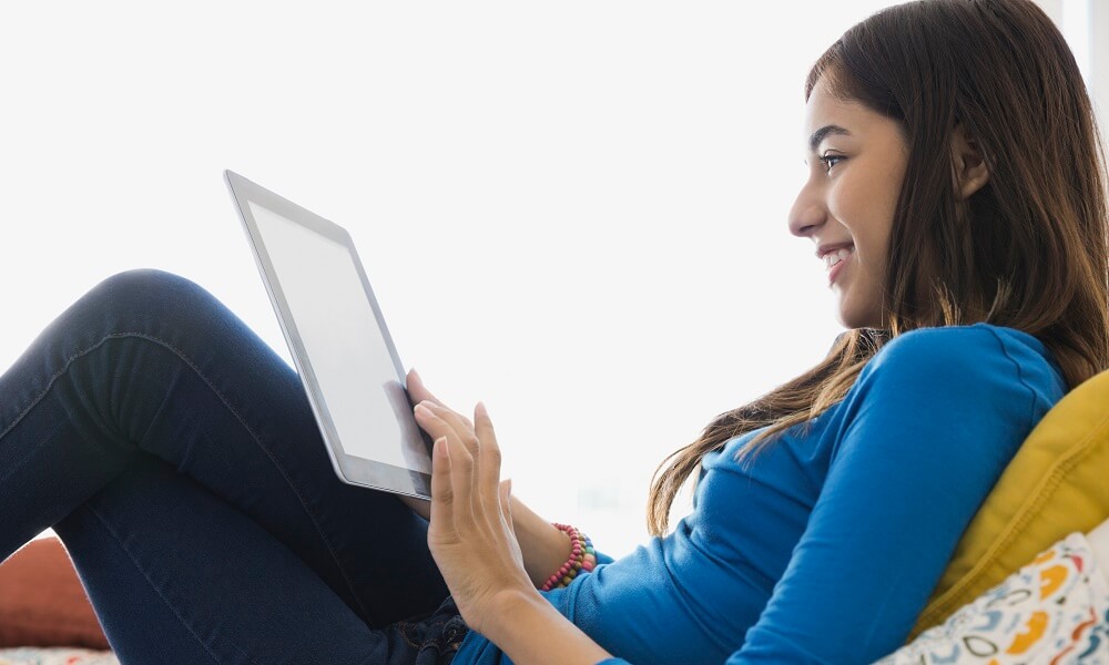 Girl using digital tablet in bedroom