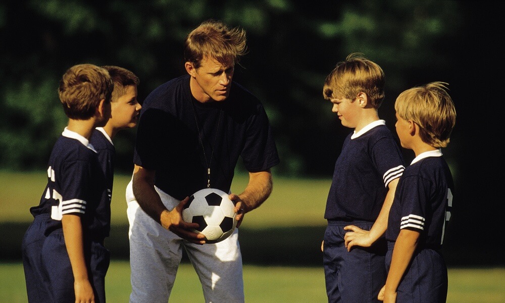 Boys with soccer coach
