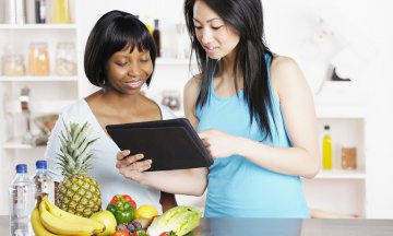 Dietician Showing Client Diet/ Food Plan On A Digital Tablet