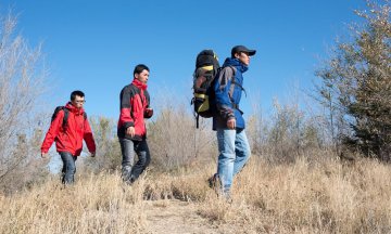 Group of people with backpacks walking along a hiking path
