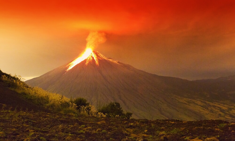 El volcán ecuatoriano Tungurahua está en plena erupción. Hay lava que fluye de la cima.