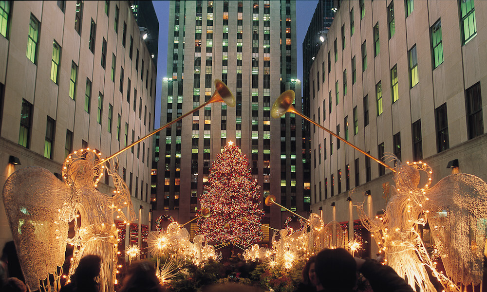 En la Plaza de Rockefeller, un árbol de navidad cubierto con miles de luces está rodeado por ángeles también iluminados..