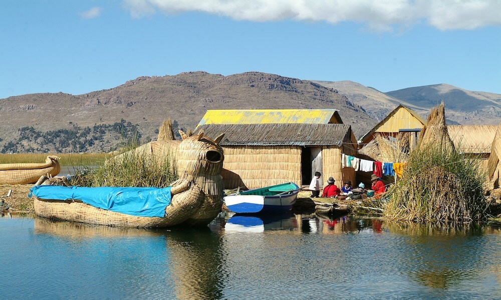 A Bolivian family outside their straw house on a floating island in Lake Titicaca.