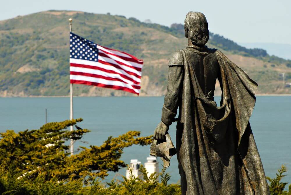 Statue of Christopher Columbus and US flag in San Francisco