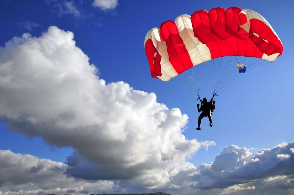 Red parachute landing with stormy sky