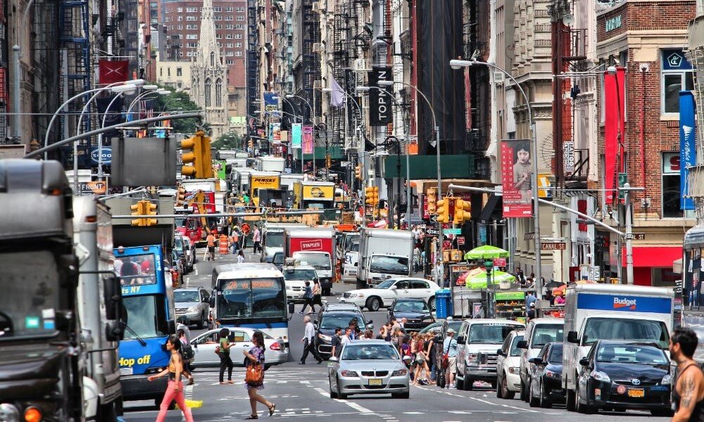 People walk along West Broadway in New York City